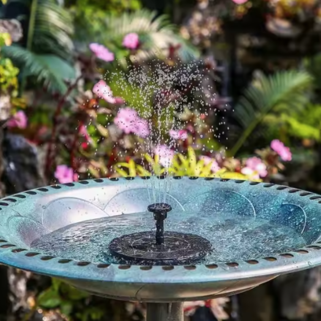 Fontänen placerad i trädgård med blommor och grönska